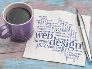 Kaffeetasse, Kugelschreiber, Serviette mit Schlagwortwolke zum Thema Webdesign