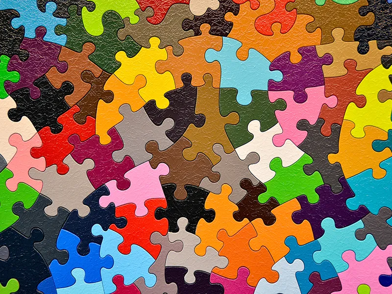 bunte Puzzleteile mit untyptischen Form zu einem Puzzle kombiniert